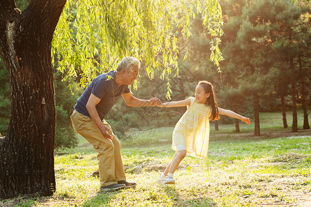 父亲白发爷爷带着孙女在公园里玩耍背景