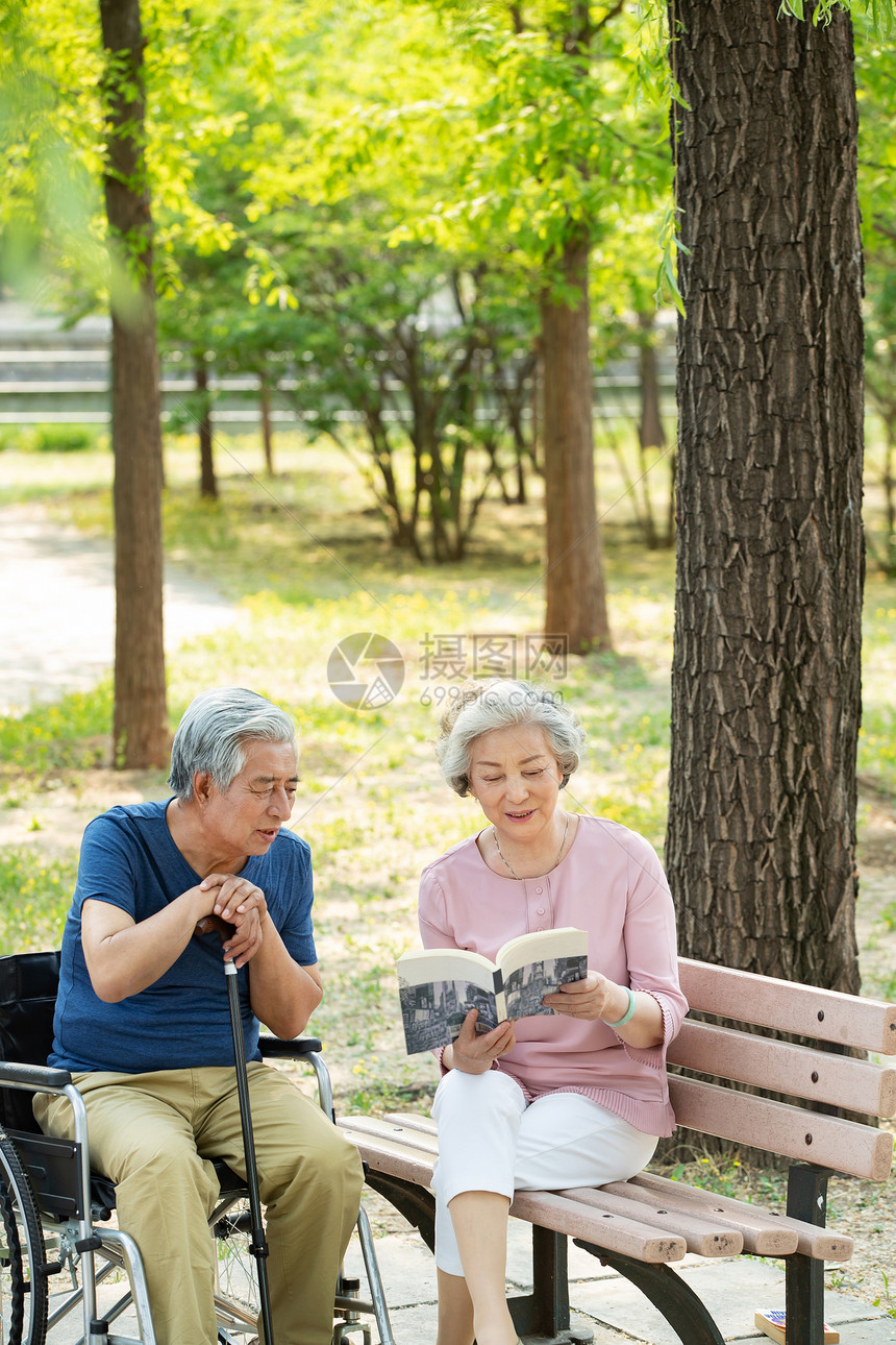 老年夫妇坐在公园里看书图片