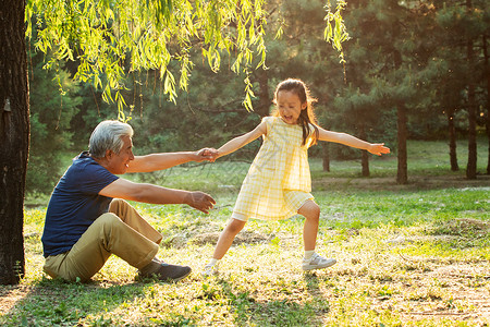 父亲白发爷爷带着孙女在公园里玩耍背景