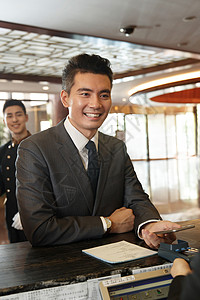 商务男士办理酒店入住登记微笑高清图片素材