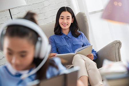 儿童生活讲座青年女人在家陪伴孩子学习背景