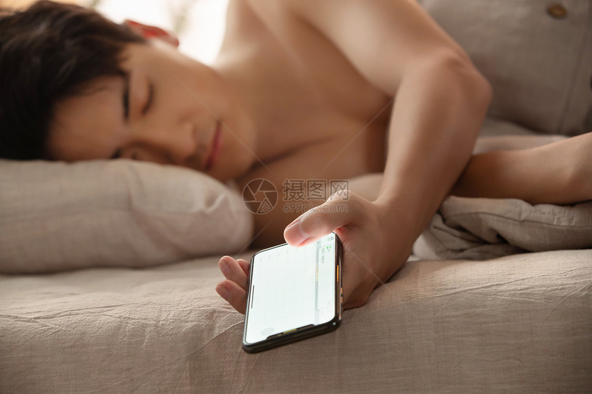 玩手机玩到睡着的年轻男人图片