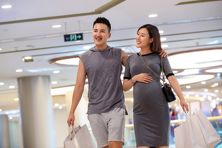 丈夫陪着怀孕的妻子在商场购物高清图片