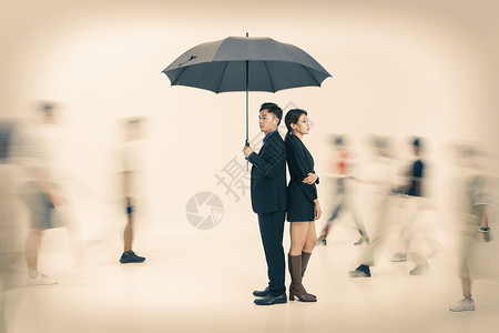 情侣雨伞拿着雨伞的商务男女站在人群中背景