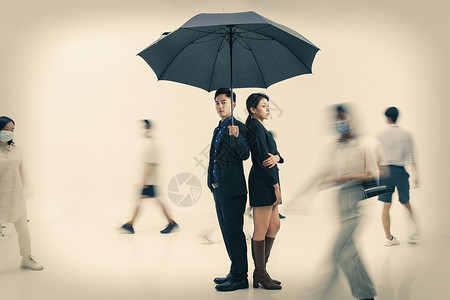 拿着雨伞的商务男女站在人群中图片素材