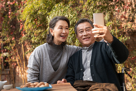 坚果视频老年夫妇在庭院使用手机自拍背景