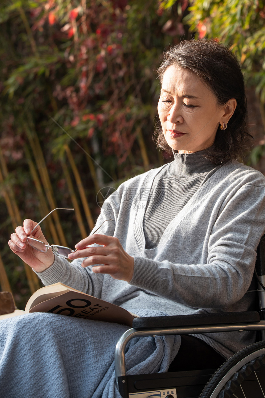 孤独的老年女人在院子里晒太阳图片