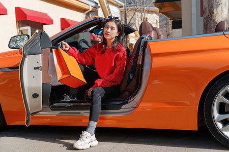汽车节促销时尚的青年女人驾驶豪车购物背景