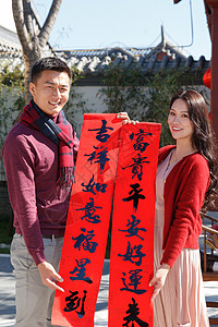 幸福的年轻夫妇拿着春联庆贺新年图片