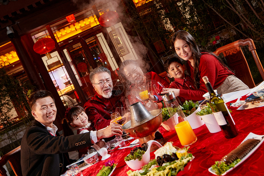 东方家庭在中式庭院内干杯庆祝新年图片