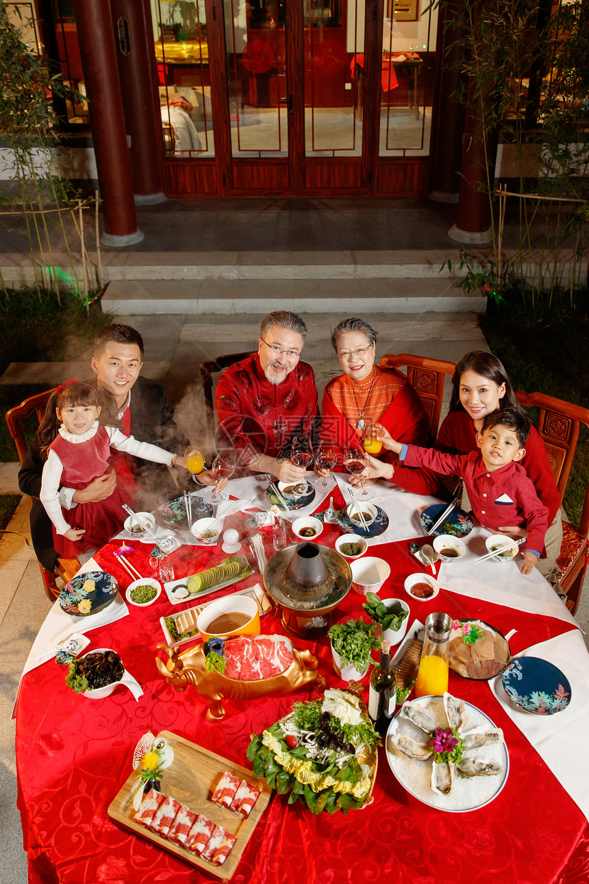 东方家庭在中式庭院内干杯庆祝新年图片