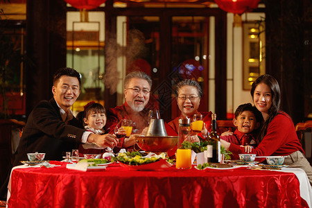 春节餐厅东方家庭在中式庭院内干杯庆祝新年背景