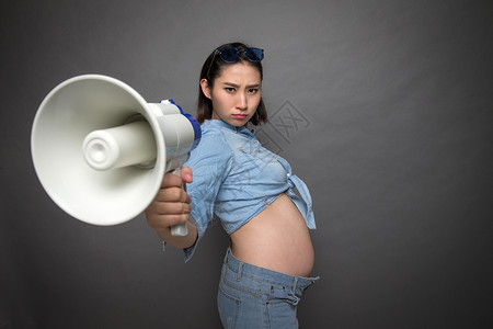 老母亲生气表情穿着时尚的孕妇拿着扩音器背景