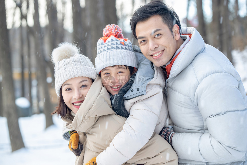 在雪地上玩耍的一家三口图片