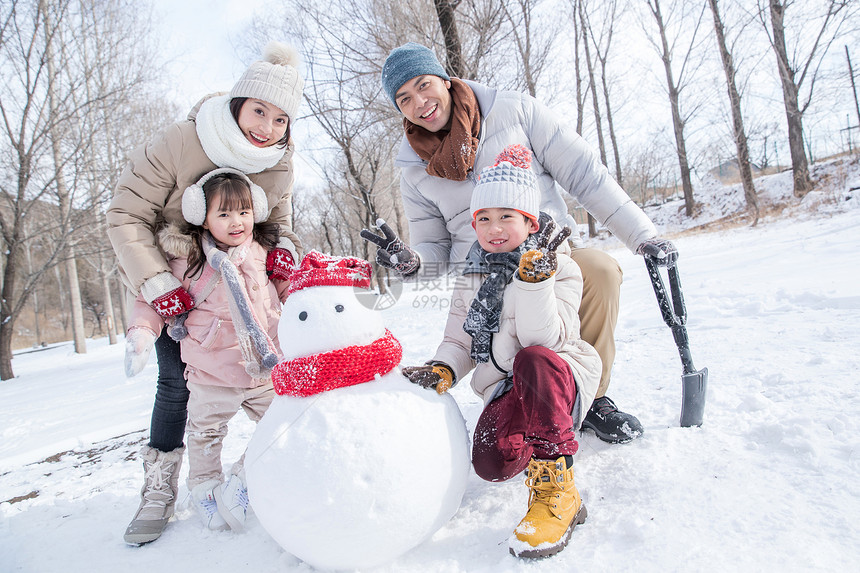 欢乐家庭在雪地里堆雪人图片