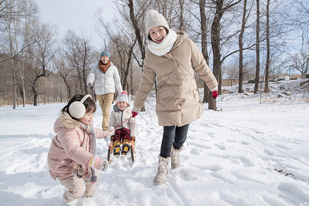 欢乐家庭在雪地上玩雪橇高清图片