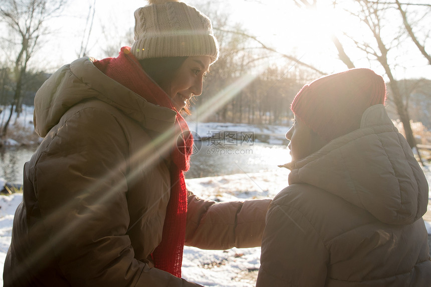 年轻妈妈和孩子在雪地上玩耍图片