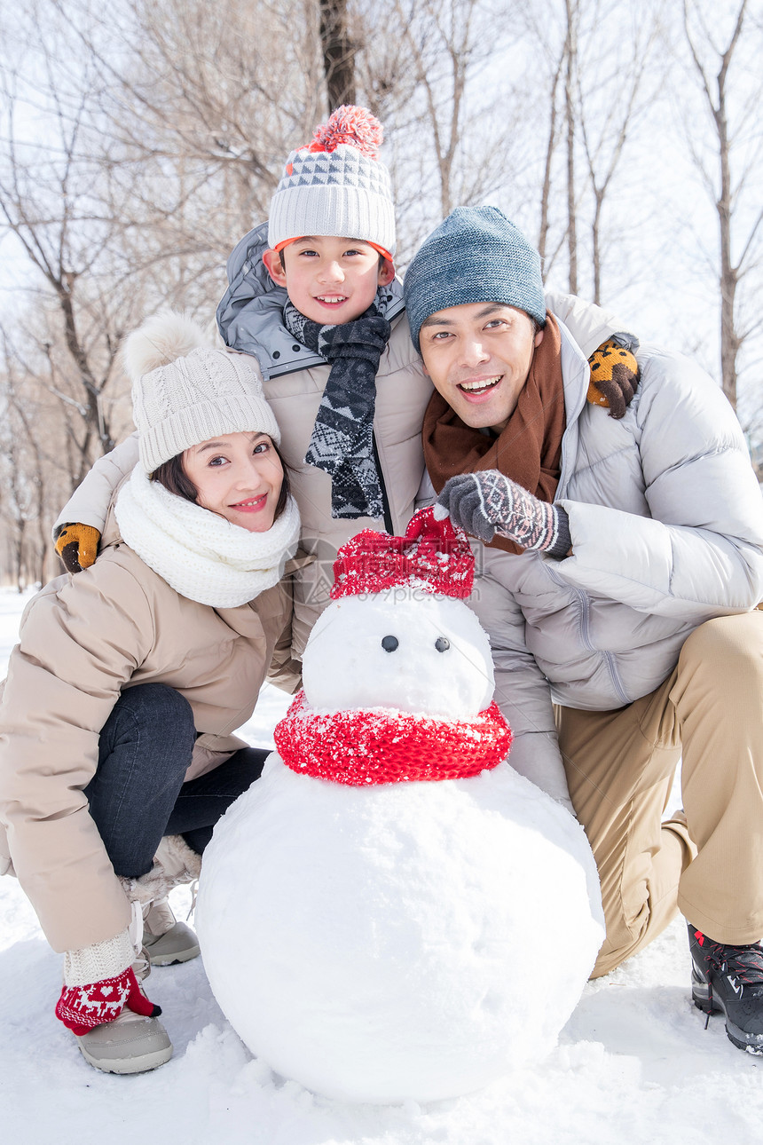 一家三口在雪地里堆雪人图片