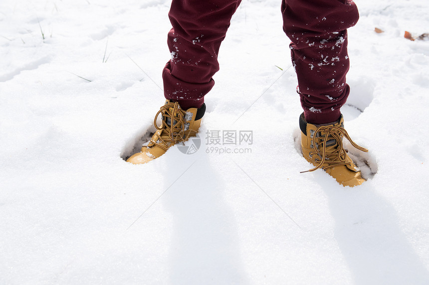 小男孩站在雪地里图片