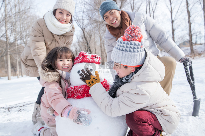 欢乐家庭在雪地里堆雪人图片