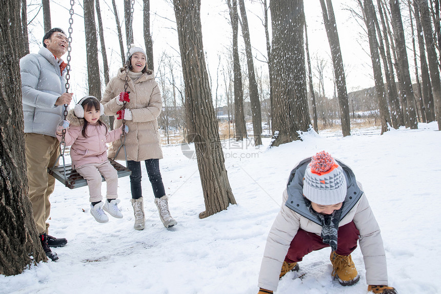 快乐家庭在雪地里玩耍图片