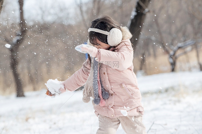 快乐的小女孩在雪地里玩耍图片