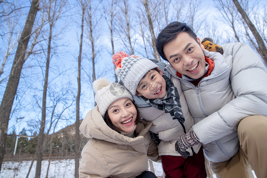 在雪地上玩耍的一家三口图片