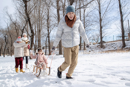 妈妈孩子玩雪欢乐家庭在雪地上玩雪橇背景