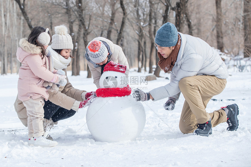 欢乐家庭在雪地里堆雪人图片