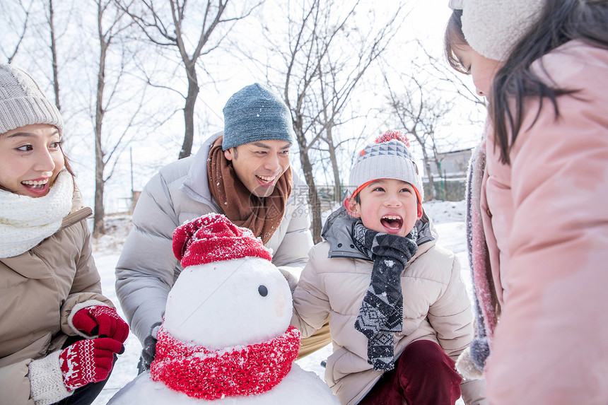 欢乐家庭在雪地里堆雪人图片