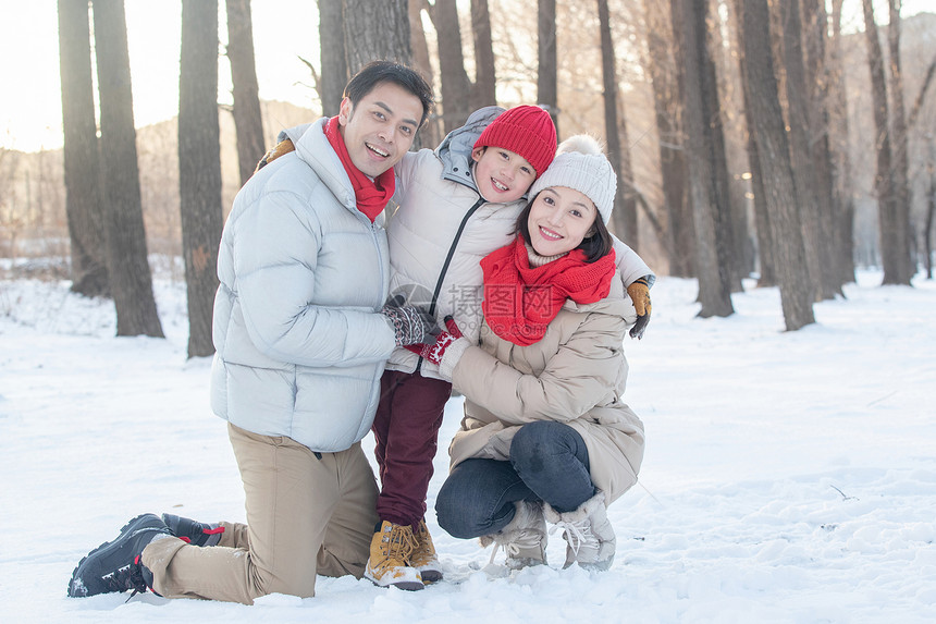 在雪地上玩耍的一家三口图片