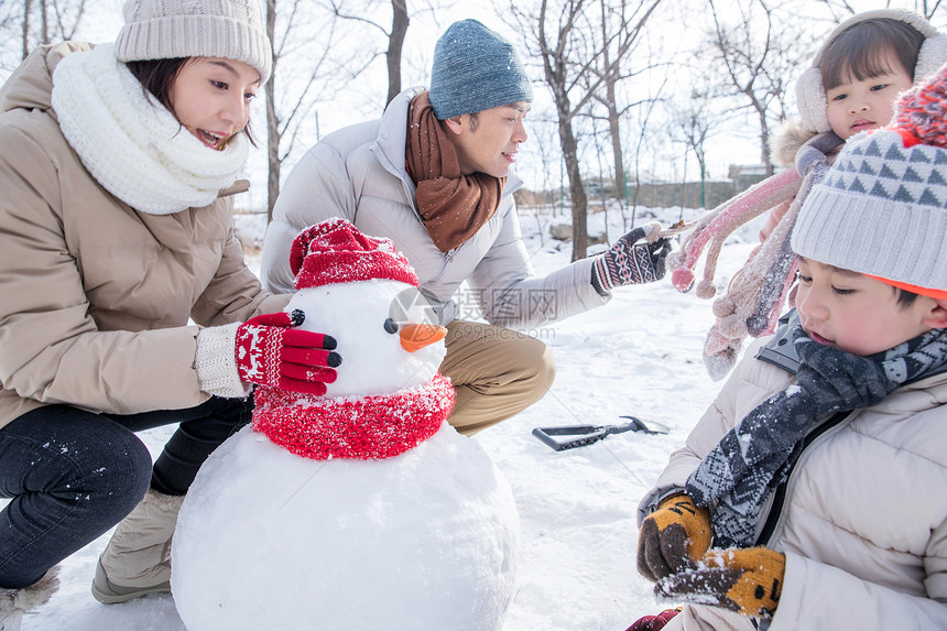 欢乐家庭在雪地里堆雪人图片