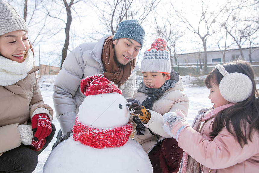 欢乐家庭在雪地里堆雪人图片