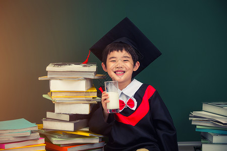 教科书文凭穿着学士服的小学男生背景