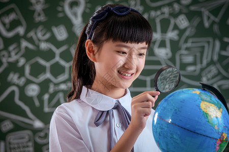 小学女生拿着放大镜看地球仪智慧高清图片素材
