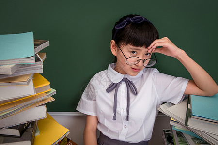 坐在书堆里的小学女生高清图片