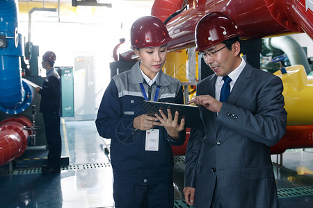 工业平板技术人员在工厂里视察工作背景