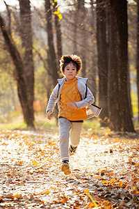 秋天快乐男孩在户外奔跑图片