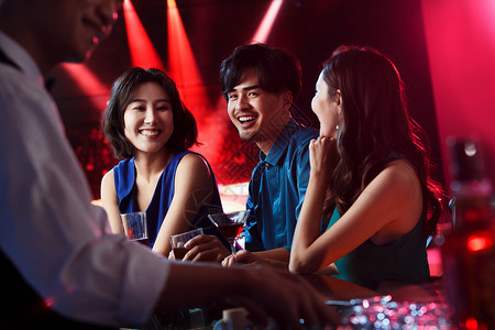 快乐的青年人在酒吧喝酒夜晚高清图片素材