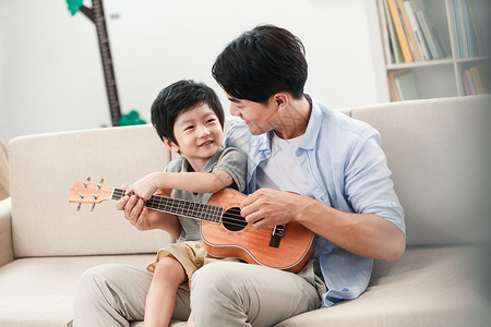 爱在教育素材快乐的父子在弹吉他背景