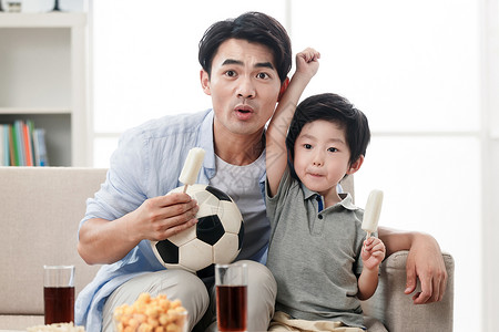 儿童大世界欢乐的父子在看足球赛背景