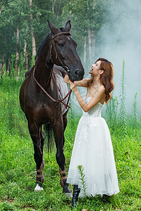 深情张亮穿婚纱的青年女人牵着马背景