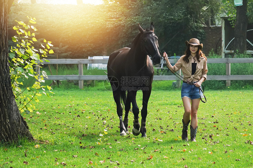 户外快乐的青年女人牵着马图片
