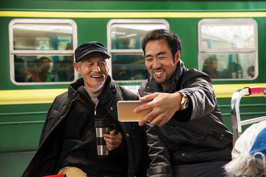 在火车站台上看手机的旅客图片
