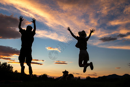 夕阳下跳跃的人夕阳下跳跃的快乐夫妇背景