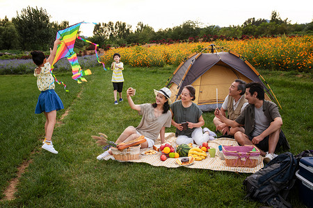 互联网生态快乐的一家人在郊外野餐背景