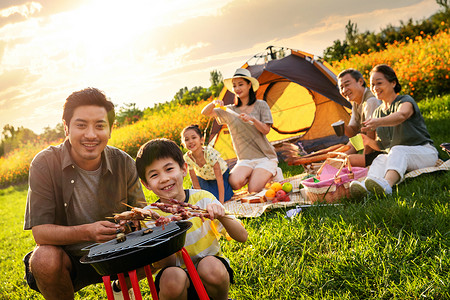 天空烧烤素材欢乐的一家人在郊外野餐烧烤背景