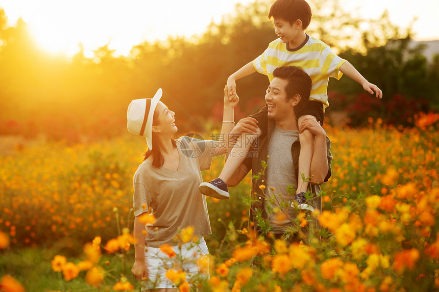 幸福的一家三口站在花丛中图片