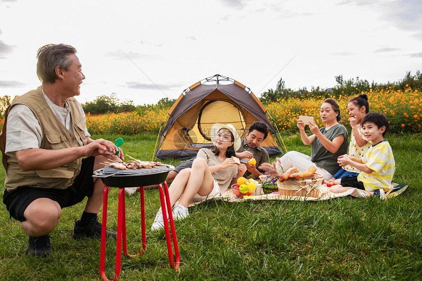 快乐家庭在郊外烧烤野餐图片