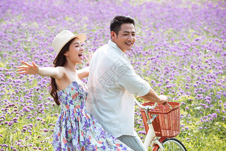 骑车旅游男人青年夫妇在花海里骑车背景